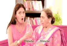 two women are sitting on a pink couch and one of them says hauru