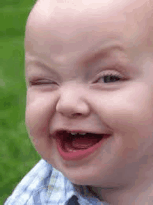 a baby is making a funny face and laughing .