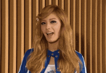 a woman with blonde hair is wearing a blue jacket and a white shirt .