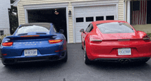 a blue porsche 911 turbo s and a red porsche 911 turbo s are parked in front of a garage