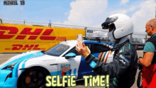 a man taking a selfie in front of a dhl building