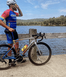 a man standing next to a bicycle that says specialized on the front