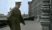 a black and white photo of a man walking down a street with the words south asian channel written on the bottom