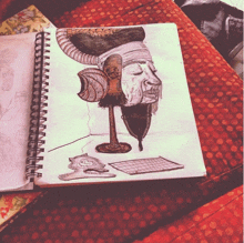 a spiral notebook with a drawing of a man 's head with horns