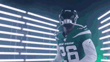 a man in a new york jets uniform is standing in front of a wall of lights