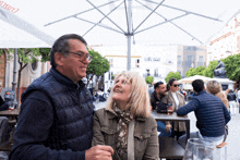 a man and woman are standing under an umbrella that says ' coca cola ' on it