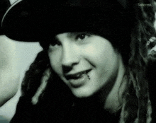 a black and white photo of a young girl wearing a hat and a piercing in her lip .