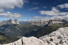 a mountain range with a blue sky and clouds in the background