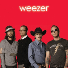 a group of men are standing in front of a red background with the word weezer above them