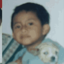 a young boy is holding a small white puppy in his arms