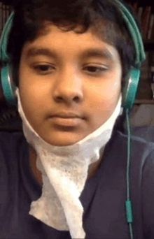 a young boy wearing headphones and a bandage around his neck