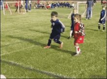 a boy and a girl are playing soccer on a field and the girl has the number 11 on her jersey