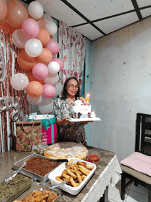 a woman holding a cake that says ' nicole ' on it