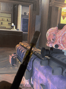 a person is holding a purple rifle with a vape pen on it