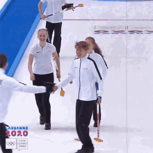 a group of people on a rink with a sign that says ' lausanne 2020 youth olympic games ' on it