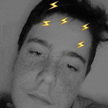 a man with lightning bolts on his forehead is taking a selfie .