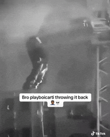 a black and white photo of a person throwing a ball on a stage .