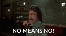 a man with a mustache is holding his fist up and saying no means no !
