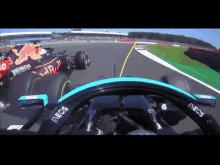 a red bull race car is driving down a track