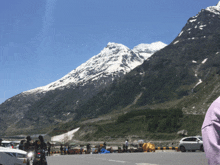 a group of people standing in front of a snowy mountain