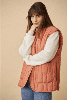 a woman wearing a white sweater and a quilted vest