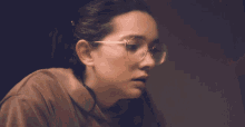 a woman wearing glasses is looking down at something