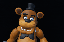 a brown teddy bear with a black top hat and blue eyes