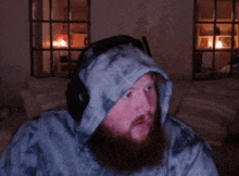 a man with a beard is wearing headphones and a hoodie