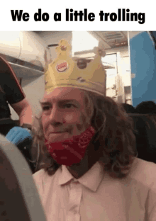 a man wearing a burger king crown on his head