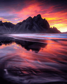 a sunset over a body of water with mountains in the distance