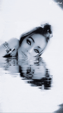 a black and white photo of a woman laying in the water with a caption that says copcut