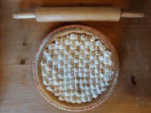 a pie sitting on a wooden table with a rolling pin