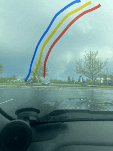 a car windshield shows a rainbow in the sky