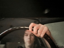 a person holding a steering wheel in a car