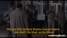 a group of men are standing in a hallway and one of them is saying we are the united states government