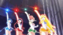 a group of sailor moon characters are standing next to each other holding up their arms and glowing in the dark .