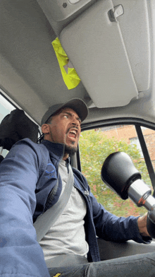 a man in a blue jacket is driving a vehicle