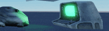 a computer with a green screen is sitting next to a rock