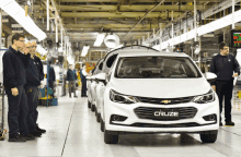 a white chevrolet cruze is being built in a factory