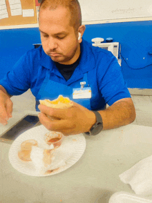 a man in a blue shirt with a name tag that says ' carlos ' on it