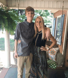 a man and a woman are posing for a photo on a porch