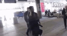 a woman is walking through an airport terminal while holding a child .