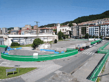 a green fence surrounds an empty parking lot in a residential area