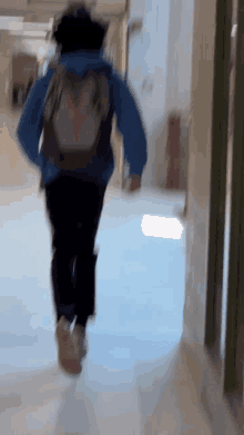 a person running down a hallway with a backpack on