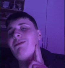 a young man is making a funny face with his finger on his face