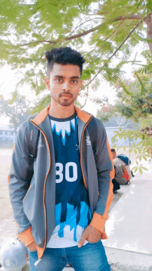 a young man wearing a jacket and a shirt with the number 30 on it