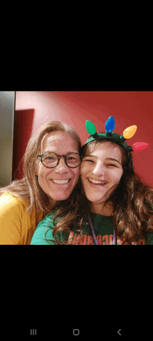 a woman wearing glasses and a girl wearing a headband with christmas lights