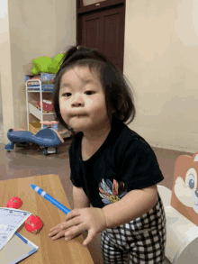 a little girl wearing a black shirt with a minnie mouse design on it