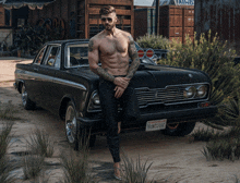 a shirtless man leans against a black car with a california license plate that reads bom324uk