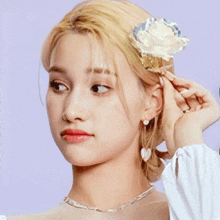 a close up of a woman wearing a necklace and earrings .